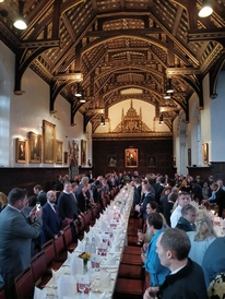 Delegates standing in St John's College Dining Hall waiting to be seated for dinner